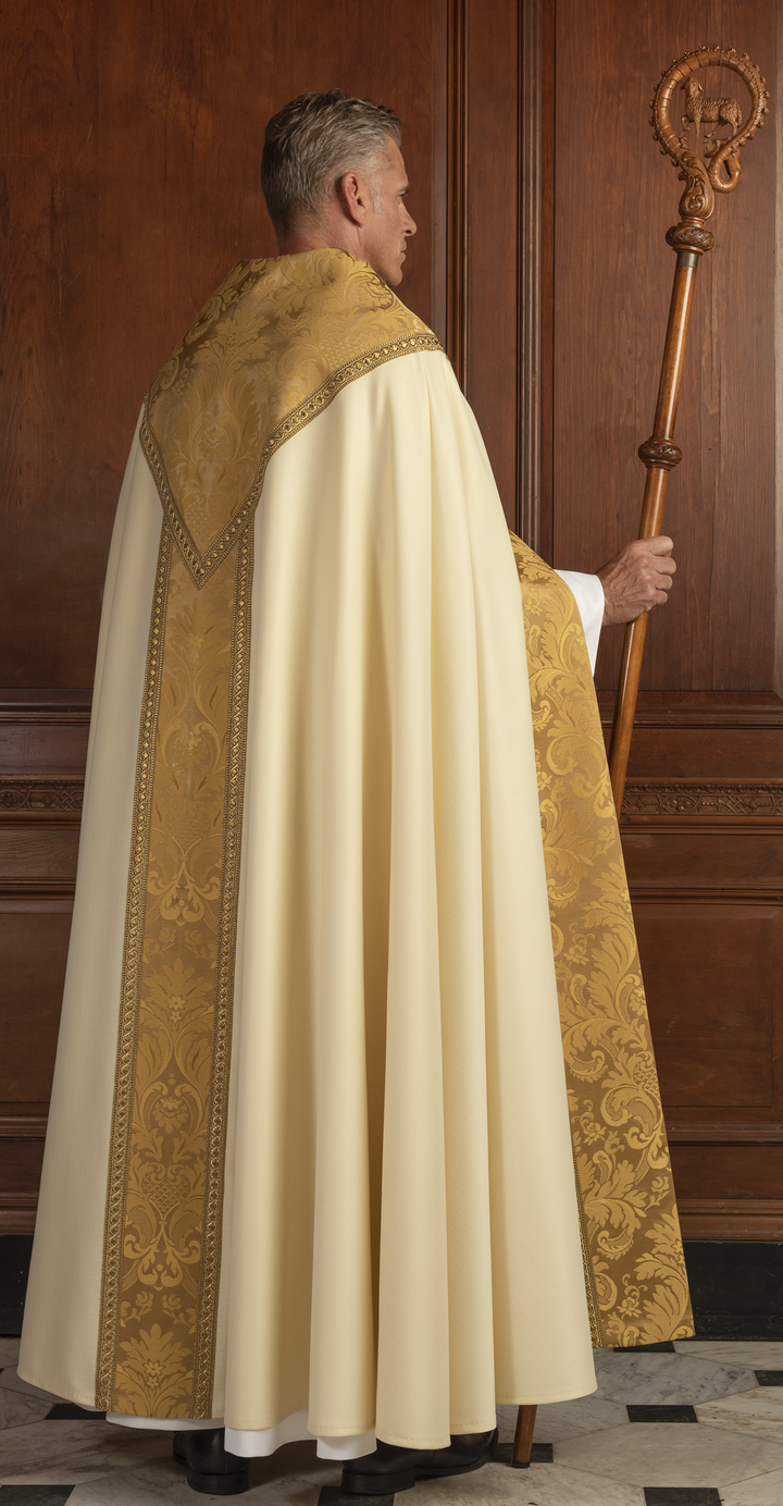 Person wearing a white and gold liturgical vestment holding a crook against a wooden paneled wall.